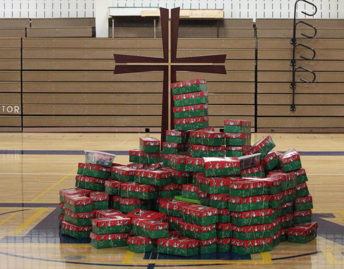 Operation Christmas Child boxes at the foot of a cross